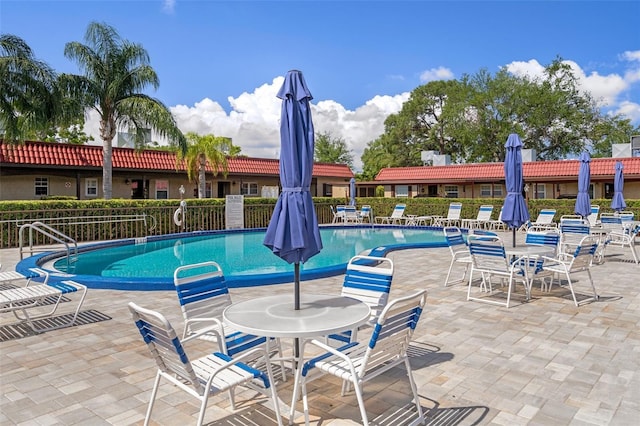 pool with a patio and fence