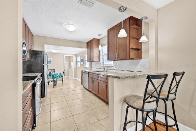 3300 Jackson St N, Saint Petersburg, FL 33704 - kitchen featuring a sink, open shelves, a breakfast bar, visible vents, and appliances with stainless steel finishes
