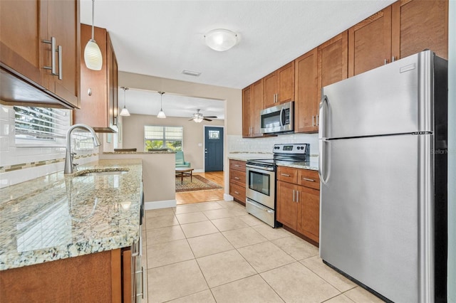 3300 Jackson St N, Saint Petersburg, FL 33704 - kitchen featuring tasteful backsplash, brown cabinetry, and appliances with stainless steel finishes