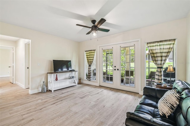 living room featuring a ceiling fan, baseboards, french doors, and light wood finished floors