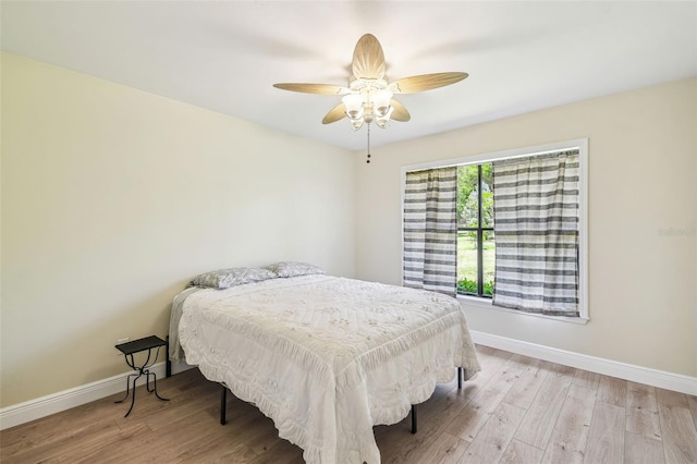 bedroom featuring baseboards, a ceiling fan, and wood finished floors