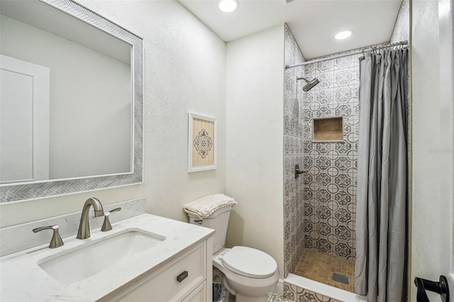 full bathroom with vanity, recessed lighting, toilet, and tiled shower