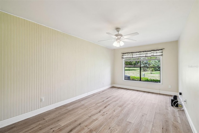 empty room with baseboards, ceiling fan, and wood finished floors