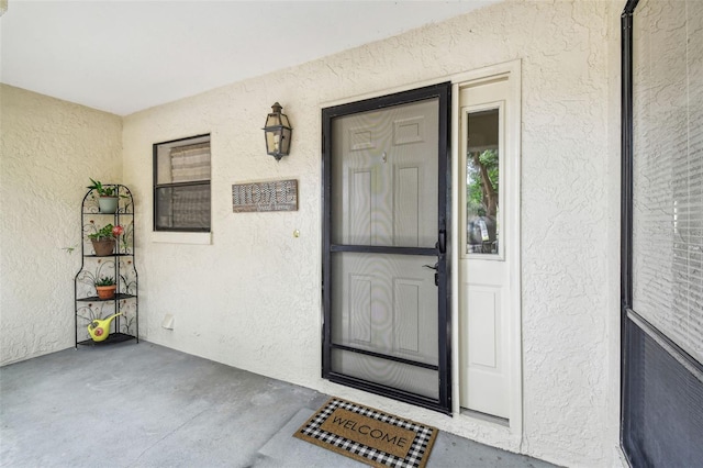 entrance to property featuring stucco siding