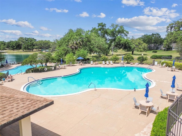 community pool with a patio and fence