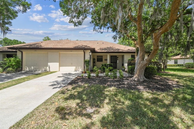 ranch-style house featuring an attached garage, a front lawn, stucco siding, and driveway