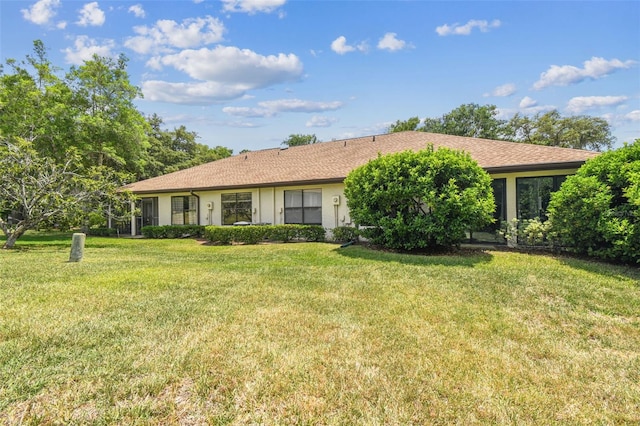 ranch-style house featuring stucco siding and a front lawn