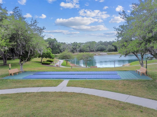 view of community featuring a lawn, a water view, and shuffleboard