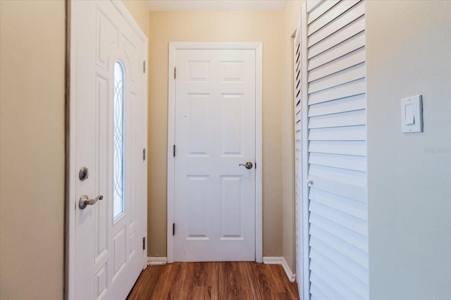 foyer featuring dark wood-style flooring and baseboards