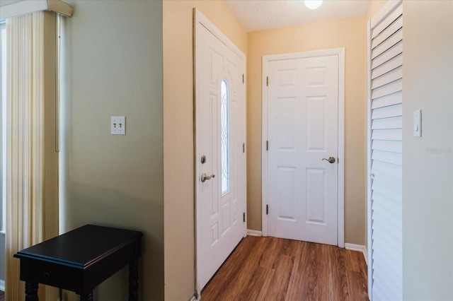 foyer entrance featuring dark wood finished floors and baseboards