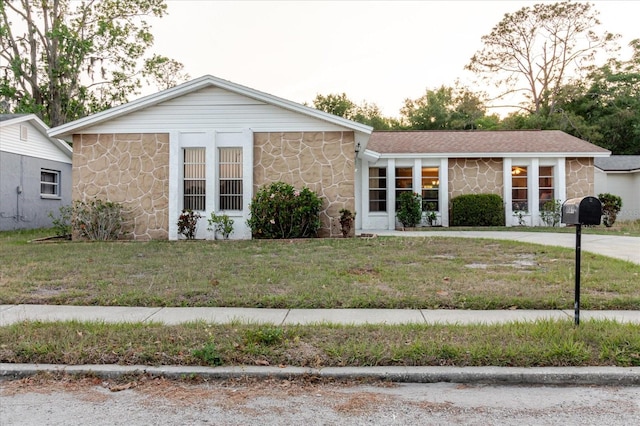 single story home with a front yard and stone siding
