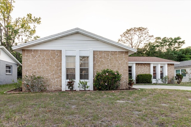 view of front of home with a front lawn and stone siding
