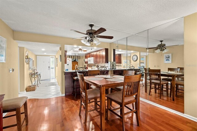 1817 Golfview Dr Unit 1817, Tarpon Springs, FL 34689 - dining space featuring a textured ceiling, a ceiling fan, and light wood finished floors