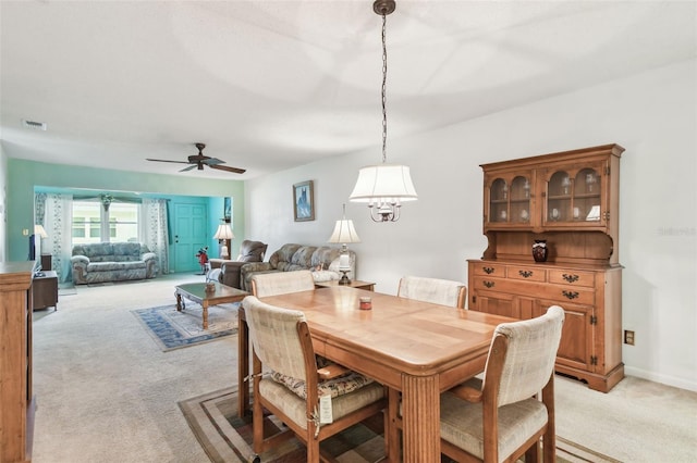 dining area with visible vents, a ceiling fan, and light carpet