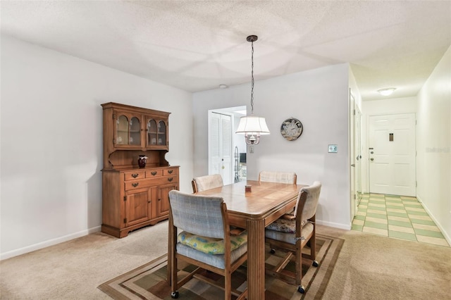 dining area featuring baseboards and light colored carpet