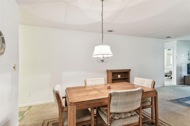 dining area featuring baseboards, visible vents, and light colored carpet