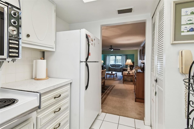 kitchen with stainless steel microwave, light countertops, visible vents, a ceiling fan, and light tile patterned flooring