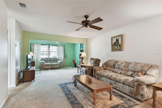 living area featuring a ceiling fan, visible vents, light colored carpet, and baseboards