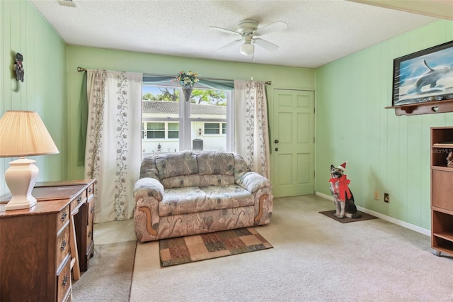 carpeted living room featuring ceiling fan and a textured ceiling