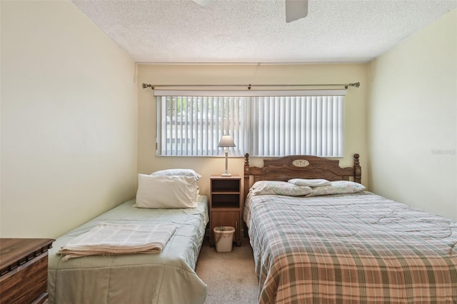 bedroom with carpet, a ceiling fan, and a textured ceiling