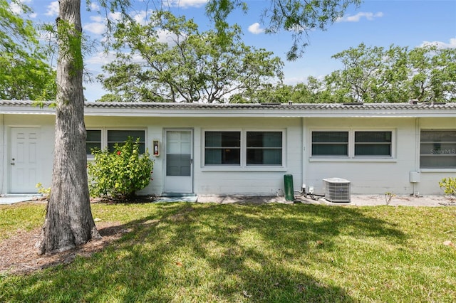 back of property featuring a lawn and central AC