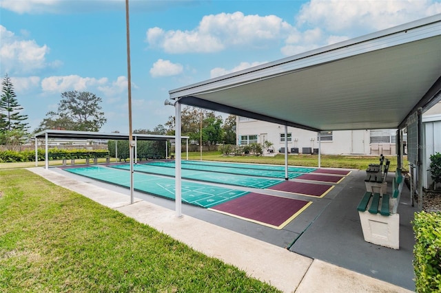 view of pool with a lawn and shuffleboard