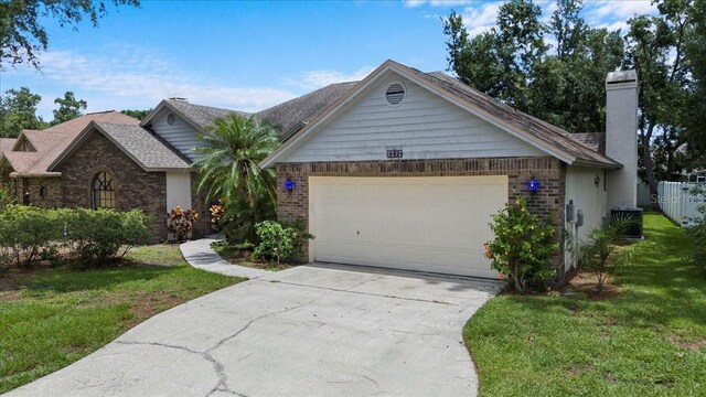 3808 Hollow Wood Dr, Valrico, FL 33594 - ranch-style house featuring a front yard, a garage, concrete driveway, and brick siding