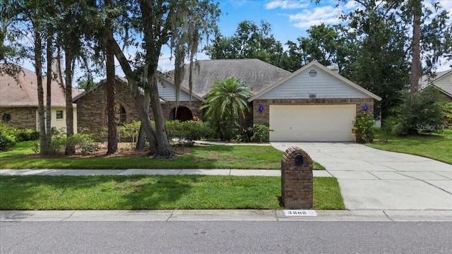 3808 Hollow Wood Dr, Valrico, FL 33594 - view of front of property featuring driveway, a garage, a front yard, and stone siding