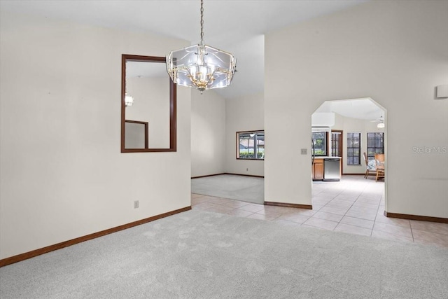 3808 Hollow Wood Dr, Valrico, FL 33594 - carpeted spare room featuring a chandelier, tile patterned flooring, arched walkways, and a towering ceiling