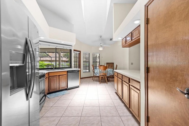 3808 Hollow Wood Dr, Valrico, FL 33594 - kitchen featuring stainless steel appliances, brown cabinets, light countertops, light tile patterned flooring, and ceiling fan