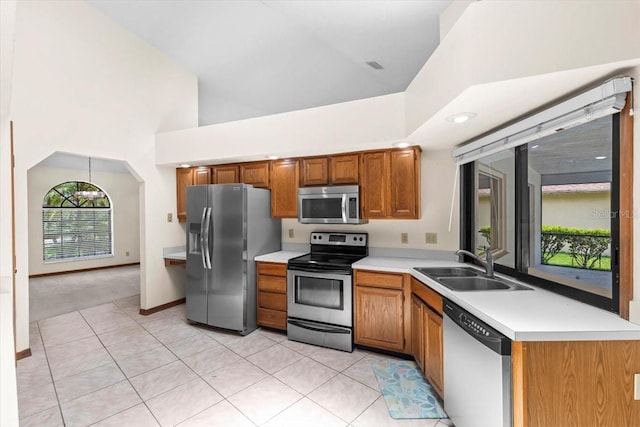 3808 Hollow Wood Dr, Valrico, FL 33594 - kitchen featuring appliances with stainless steel finishes, high vaulted ceiling, brown cabinets, light countertops, and light tile patterned floors