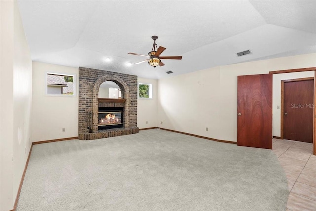 3808 Hollow Wood Dr, Valrico, FL 33594 - unfurnished living room with healthy amount of natural light, a fireplace, a ceiling fan, lofted ceiling, and light colored carpet