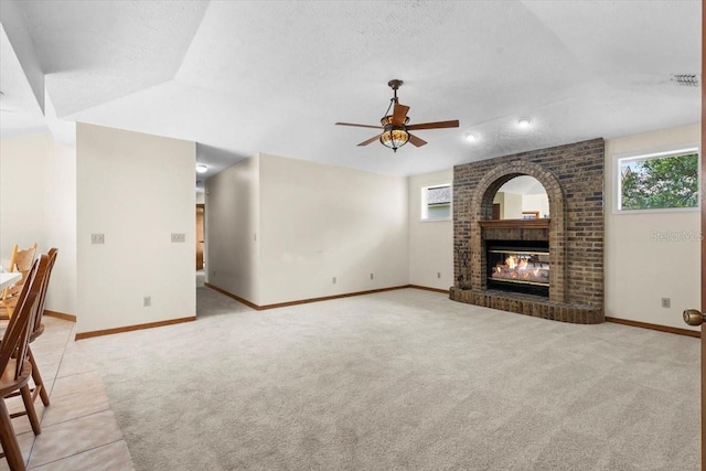 3808 Hollow Wood Dr, Valrico, FL 33594 - unfurnished living room with plenty of natural light, ceiling fan, light carpet, a brick fireplace, and a textured ceiling