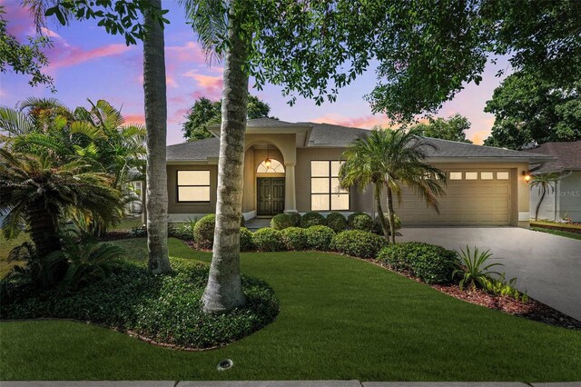 1118 Captains Way, Tarpon Springs, FL 34689 - view of front of home featuring an attached garage, stucco siding, driveway, and a front yard
