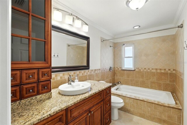 bathroom featuring crown molding, tile patterned flooring, vanity, toilet, and tiled shower / bath combo