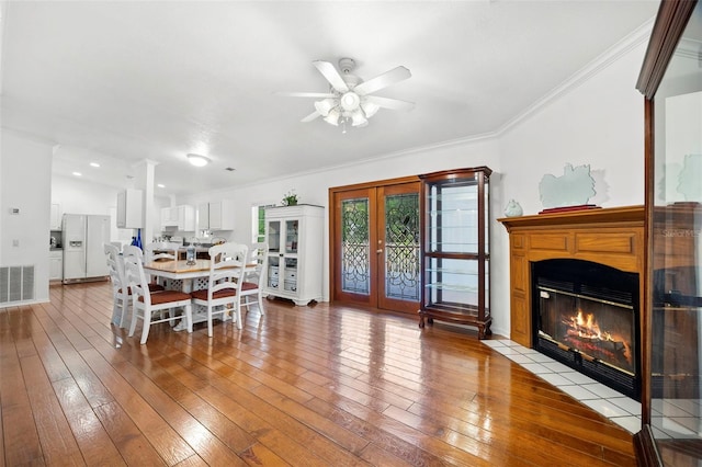 13015 Elm St, Odessa, FL 33556 - dining room with light wood finished floors, a fireplace with flush hearth, ceiling fan, crown molding, and visible vents