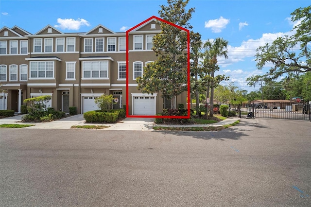 3056 Pointeview Dr, Tampa, FL 33611 - view of property with an attached garage, a gate, stucco siding, fence, and driveway