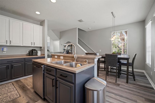 3056 Pointeview Dr, Tampa, FL 33611 - kitchen with a center island with sink, white cabinetry, a sink, dark wood finished floors, and dishwasher