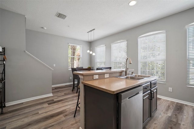 3056 Pointeview Dr, Tampa, FL 33611 - kitchen with a sink, dishwasher, light countertops, wood finished floors, and a center island with sink