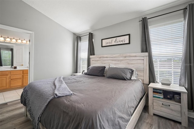 3056 Pointeview Dr, Tampa, FL 33611 - bedroom with ensuite bathroom, lofted ceiling, and light wood-style floors
