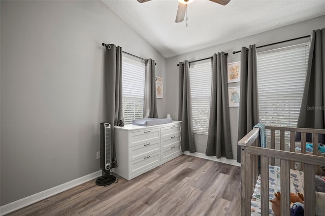 3056 Pointeview Dr, Tampa, FL 33611 - bedroom with baseboards, a nursery area, ceiling fan, vaulted ceiling, and light wood-style floors