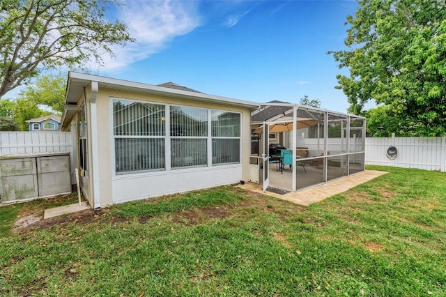 back of house with a patio, a lawn, a sunroom, and a fenced backyard