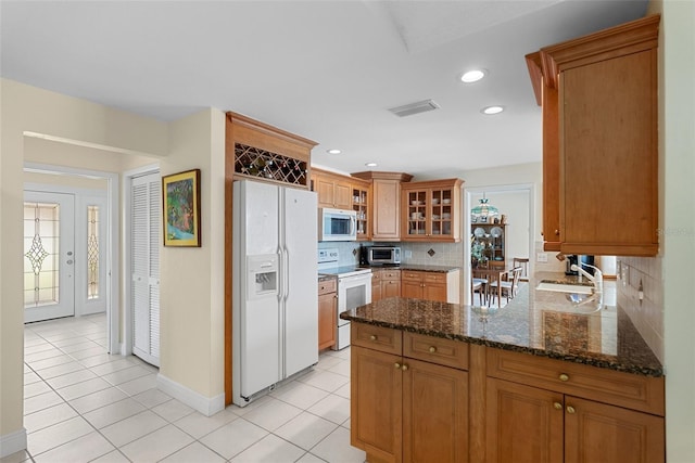 4333 48th Ave S, Saint Petersburg, FL 33711 - kitchen featuring light tile patterned floors, a sink, tasteful backsplash, and white appliances