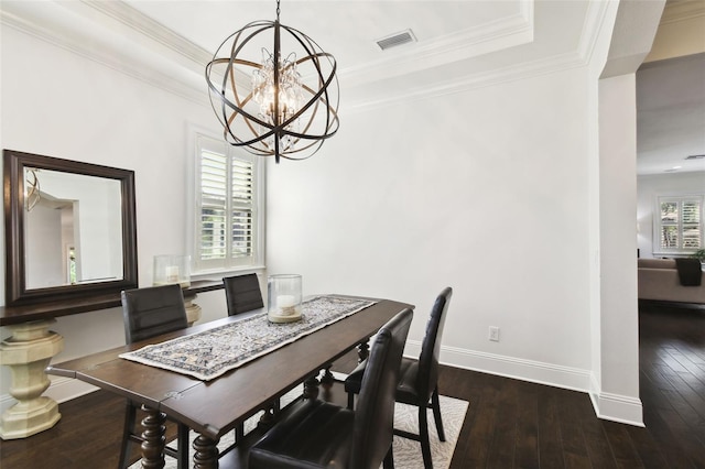 dining area featuring an inviting chandelier, a raised ceiling, dark wood-type flooring, visible vents, and baseboards