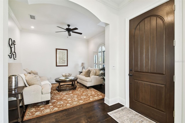 foyer entrance with dark wood finished floors, arched walkways, ceiling fan, baseboards, and visible vents