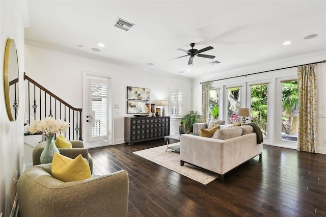 living area featuring hardwood / wood-style flooring, visible vents, ceiling fan, baseboards, and ornamental molding