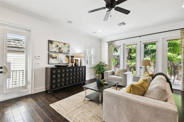living area featuring crown molding, visible vents, wood-type flooring, baseboards, and a ceiling fan