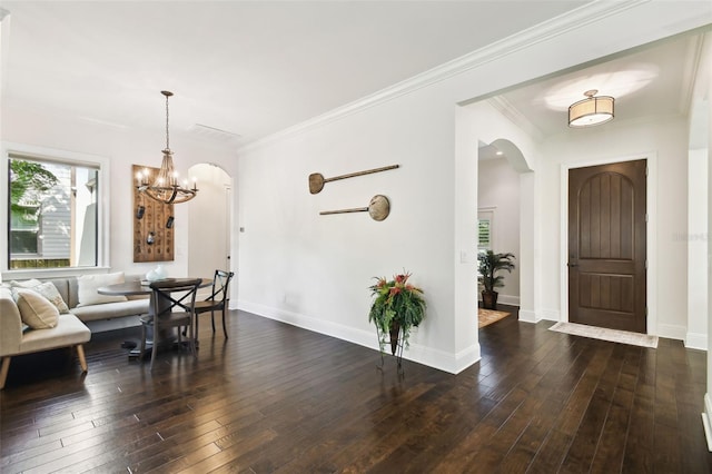 dining space featuring a notable chandelier, crown molding, baseboards, arched walkways, and dark wood finished floors