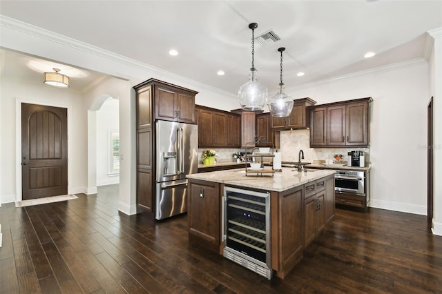 kitchen with appliances with stainless steel finishes, dark brown cabinetry, baseboards, light stone countertops, and wine cooler