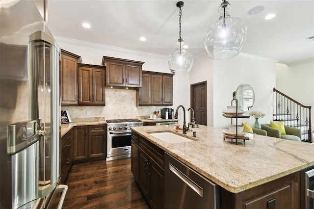 kitchen featuring light stone countertops, stainless steel appliances, dark wood-style flooring, a sink, and a center island with sink